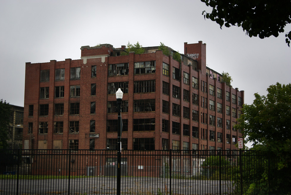 The empty 7-story structure sits on Orchard Street just south of Lyell Ave. and straddles a former railroad line.