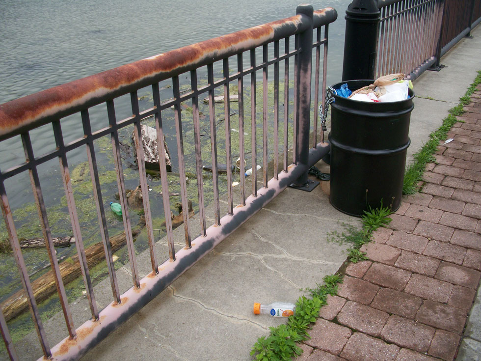 An overflowing garbage can next to the Genesee River. [PHOTO: RochesterSubway.com]
