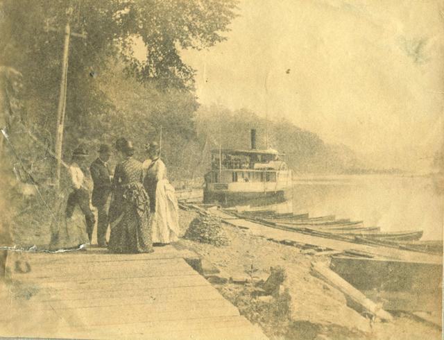 Passengers wait to board the City of Rochester steamboat at the Glen House resort boat landing. Looking down lower falls. The steamer leaves here for the mouth of river and Lake Ontario about 5 miles north. Sometimes it travels as far as Seabreeze. c.1886-1889. [PHOTO: Rochester Public Library]