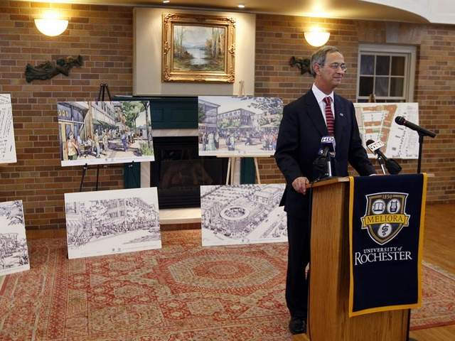 University of Rochester president Joel Seligman showing off plans for College Town. Original plans included an enclosed public transit center. The latest plans include twice as much parking as originally called for and no transit center. [PHOTO: Democrat & Chronicle]
