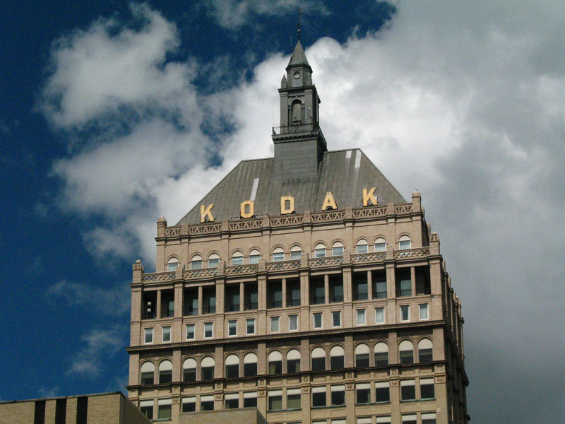 Kodak Tower TODAY: as it stands today with bad windows that don't fit the openings, dirty patched up roof, dinged up sign, and a cupola that is painted gray for some reason.