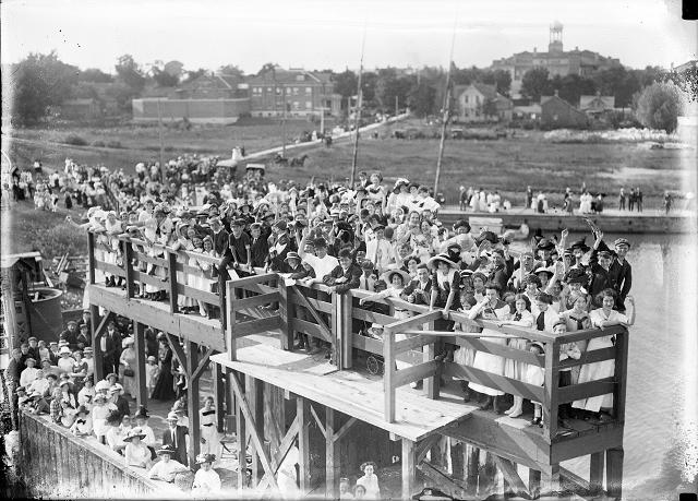 Crowd on docks in Coburg waving as the car ferry Ontario I leaves. Rochester Common Council outing in Coburg. August 4, 1912. [PHOTO: Albert R. Stone]