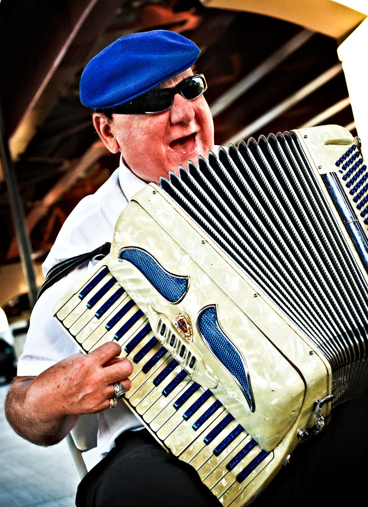 Walter, Rochester's accordion man, performing underneath the Freddie-Sue bridge in Corn Hill as a crowd gathers for the Eddie Money 'Party in the Park' concert [PHOTO: Jeff Gerew, C7Photo.com]