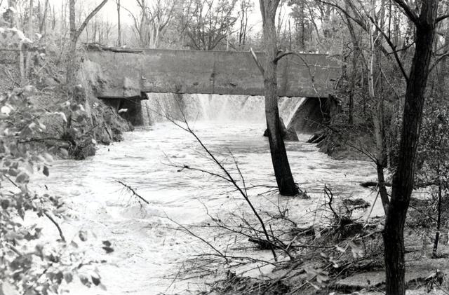 This view shows the water pouring out of the canal from below. A wall of water about two stories high ripped through residential streets damaging 69 homes. [PHOTO: Perinton Municipal Historian collection]