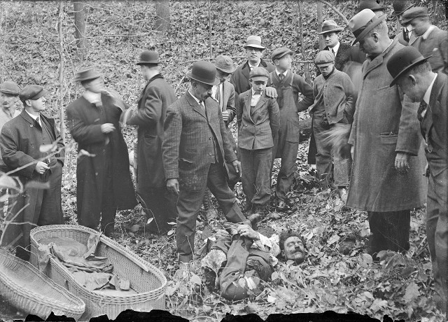 Detectives, men from the coroner's office, and bystanders gather around Francesco Manzello's dismembered body. It was found in a gully in Webster, packed into a whiskey barrel. The parts of the body had been folded up to fit into the barrel: his arms clasp his legs, which have been reversed, and his head rests on his arms and feet.  [PHOTO: Albert R. Stone]