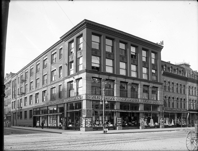 The McCurdy & Norwell Company department store was located at 285-291 Main Street East, at the corner of Elm Street. The display windows are crowded with goods. The store occupied several attached buildings of various heights and styles. c.1901-1913 [PHOTO: Albert R. Stone Collection]