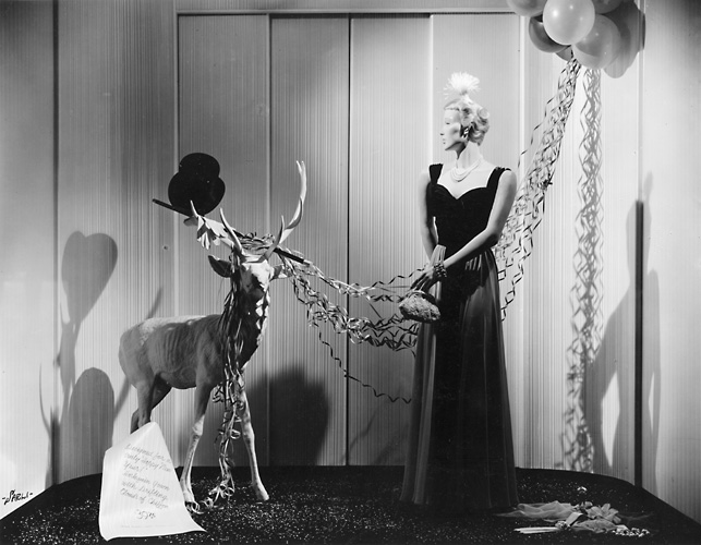 This scene shows a mannequin in an evening gown with a reindeer. c.1940. [PHOTO: Rochester Public Library]