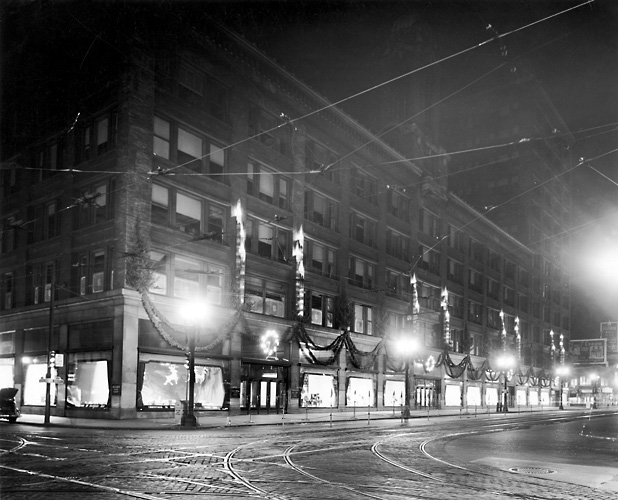 An exterior view of Sibley's as seen at nighttime and decorated for Christmas. 1939. [PHOTO: Rochester Public Library]