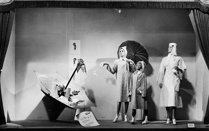 A Sibley's window display featuring mannequins wearing raincoats, pictured with umbrellas. c.1940. [PHOTO: Rochester Public Library]