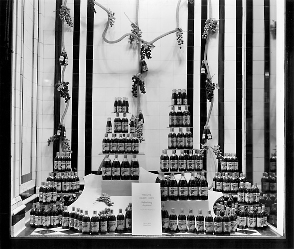 'Welch's Grape Juice. Refreshing Anytime!' A Sibley's window display featuring stacked bottles of Welch's grape juice. 1941. [PHOTO: Rochester Public Library]