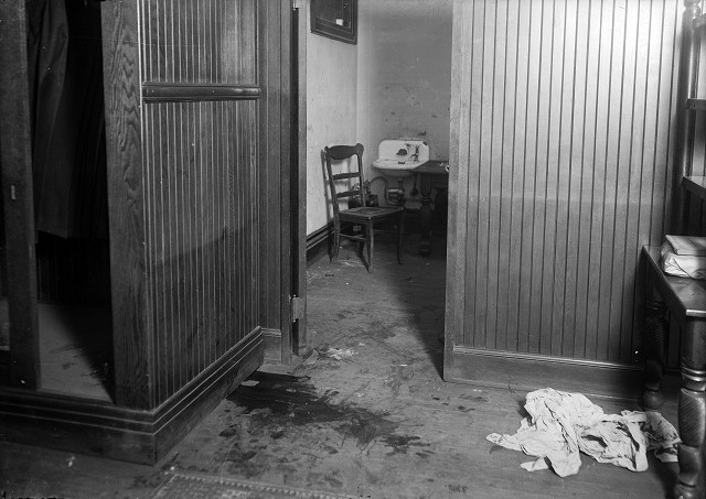 A large pool of blood marks the spot where J. Frank 'Scrappy' O'Connor bled to death. A pile of rags lies on the floor nearby. In the background is the room with a sink where the assailant washed his hands, stepping over O'Connor's body in order to do so. [PHOTO: Albert R. Stone Collection]